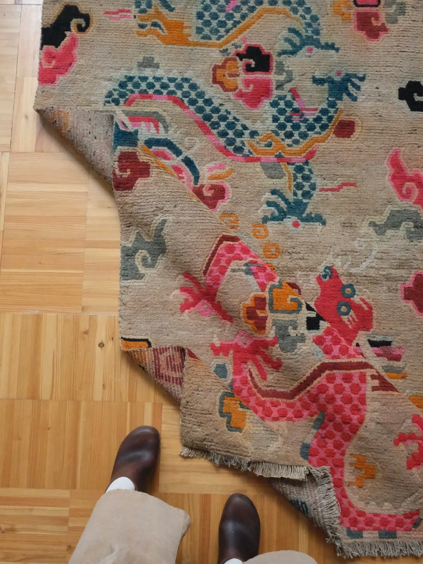 I just had to get this Tibetan dragon rug onto the grid before some lucky person scoops this one up. This rug features two dueling dragons- one in hot pink, the other in slate blue. The rest of the field is filled with colorful swirls of smoke and pu