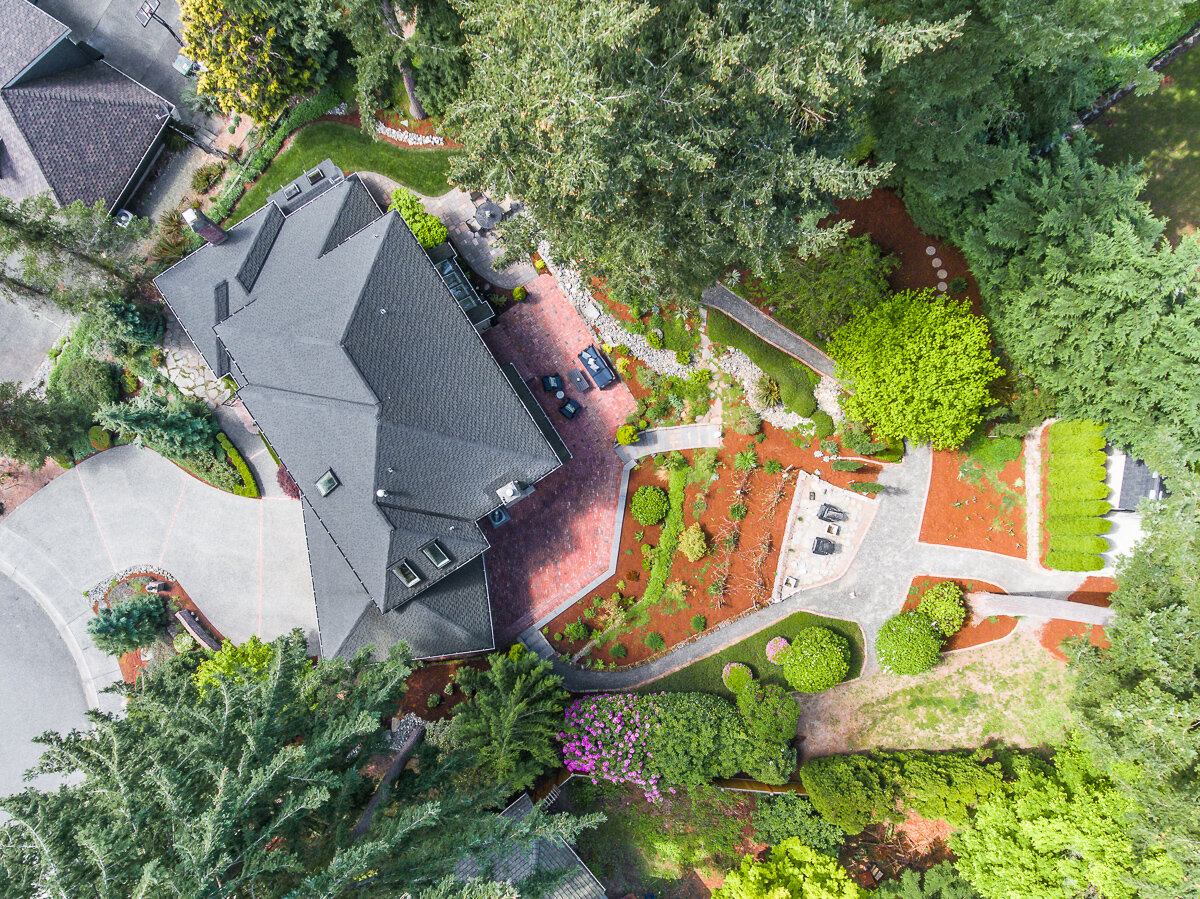aerial drone birds-eye view of house, roof and landscaping