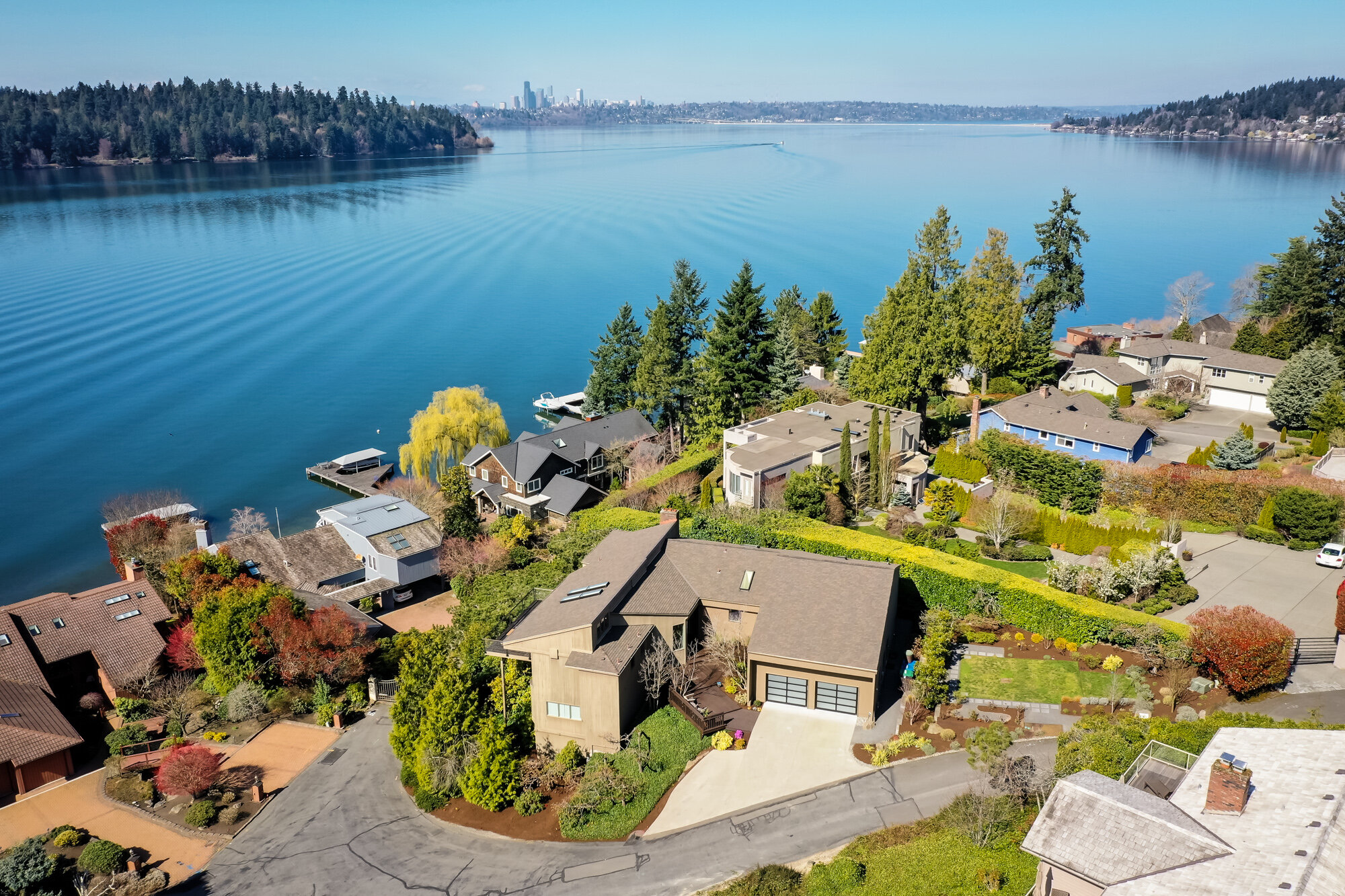 aerial view of waterfront home with lake and city skyline in the background