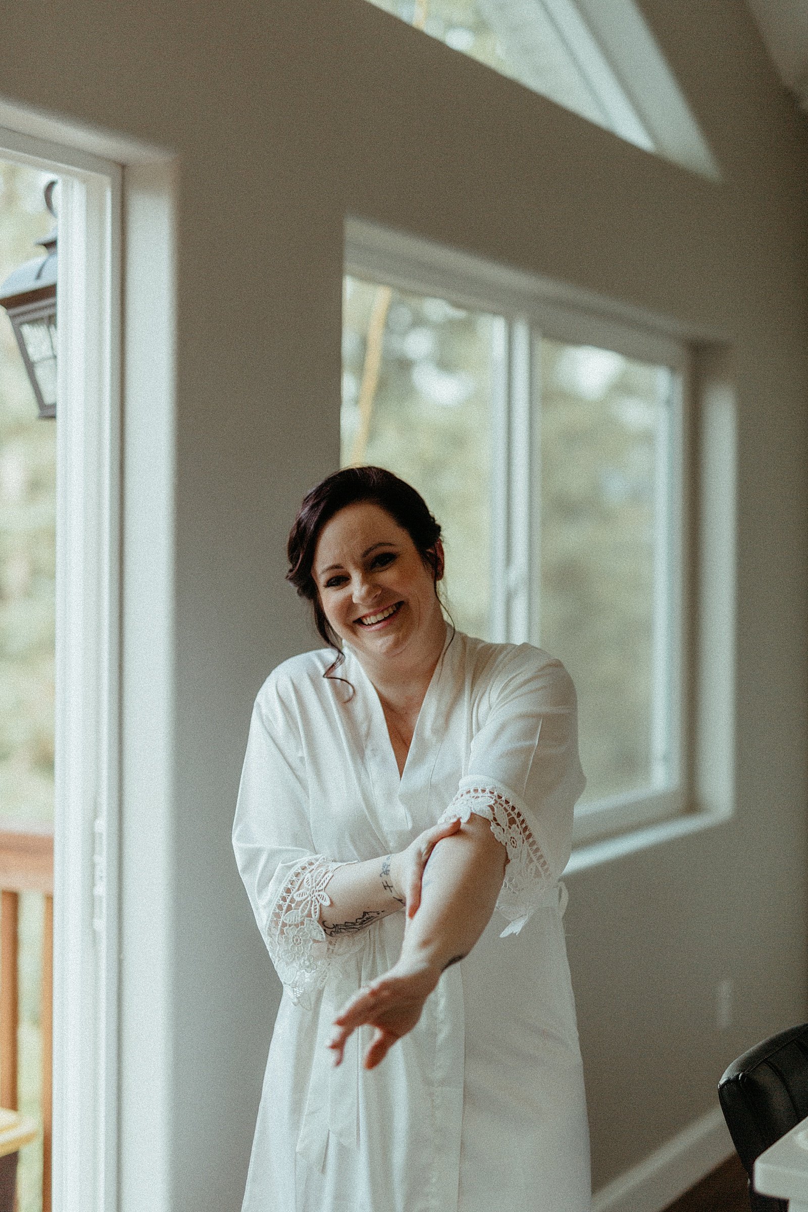  Bride in white robe getting ready before intimate elopement by Alaska photographer Rachel Struve 
