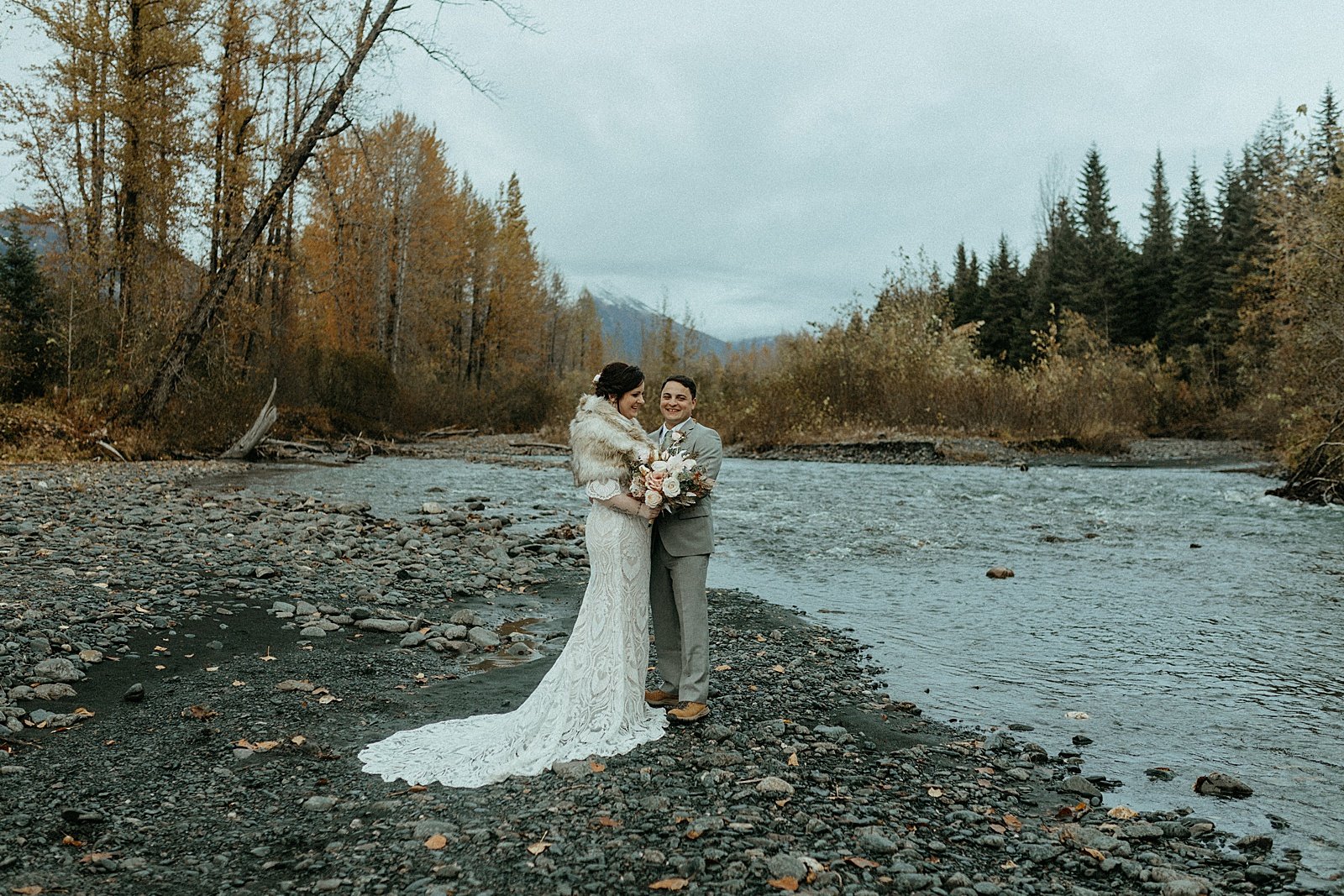  Newlyweds embracing on a riverbank in Alaska by photographer Rachel Struve 