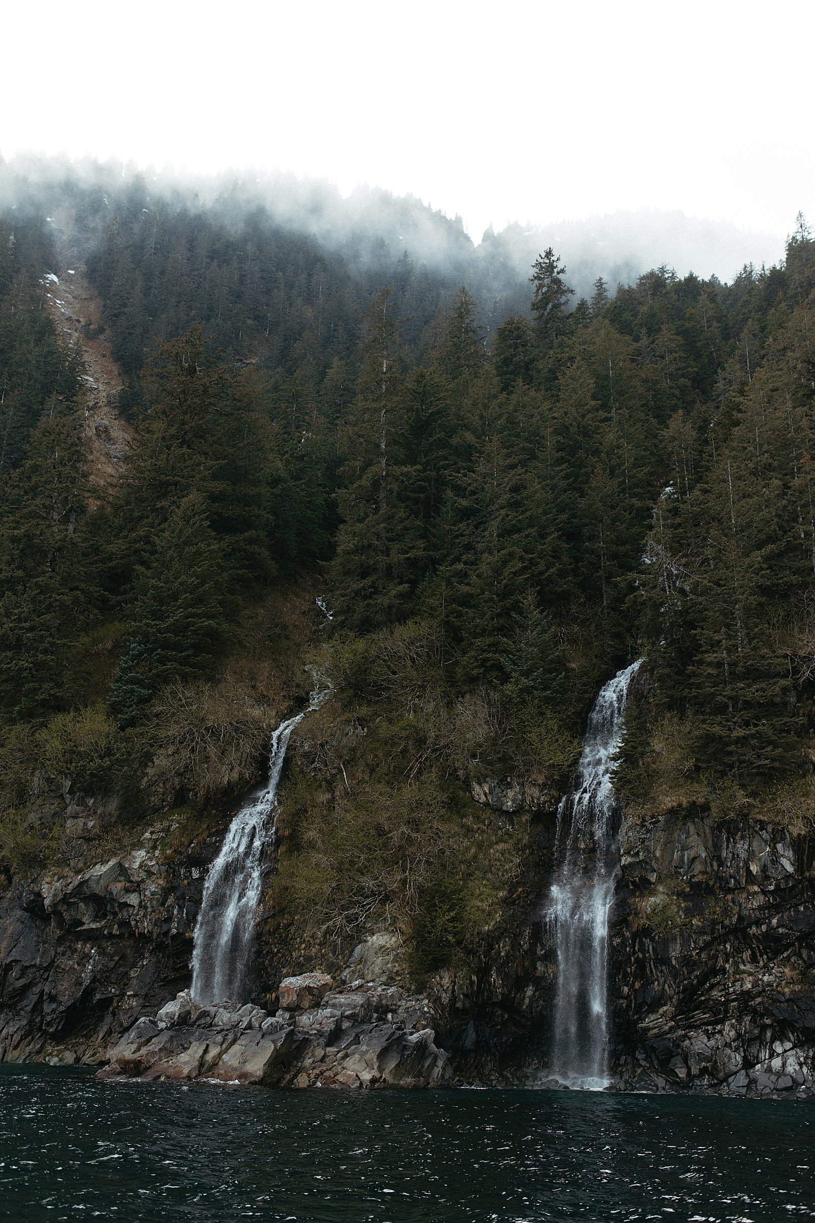  Large waterfalls off the side of a mountain into the ocean by Rachel Struve Photography 
