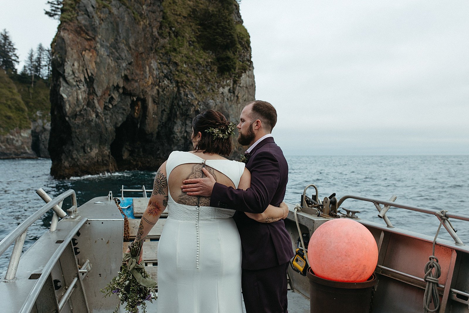  Bride and groom embracing on a boat with mountains around by Rachel Struve Photography 