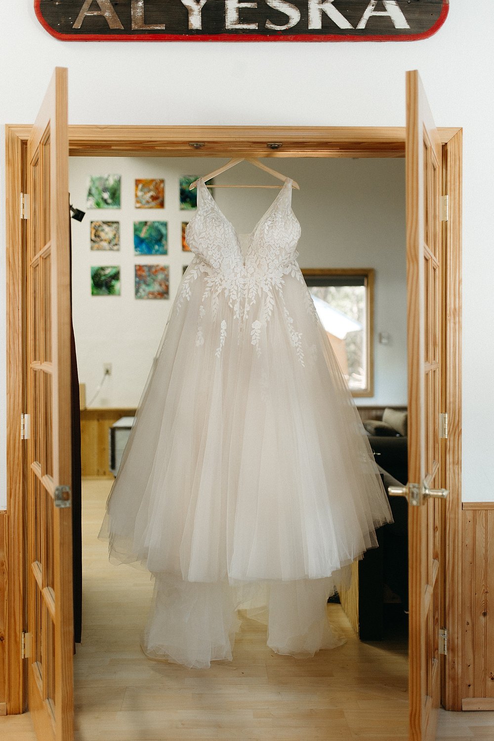  Brides dress hanging from a doorway by Alaska Elopement Photographer 