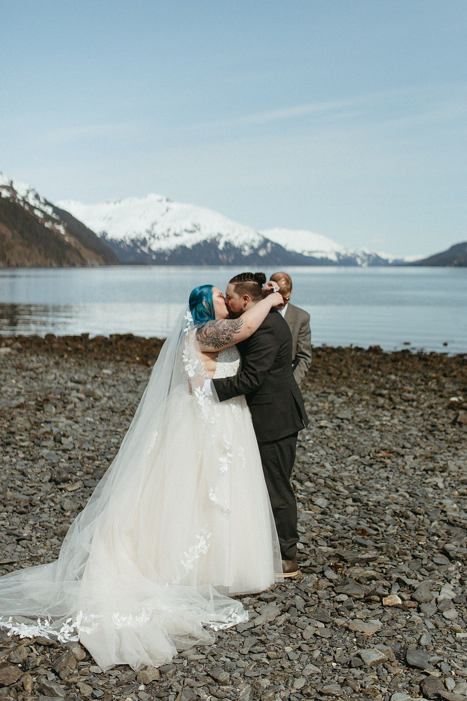  Newlyweds share a first kiss at an intimate beach elopement in Whittier Alaska 