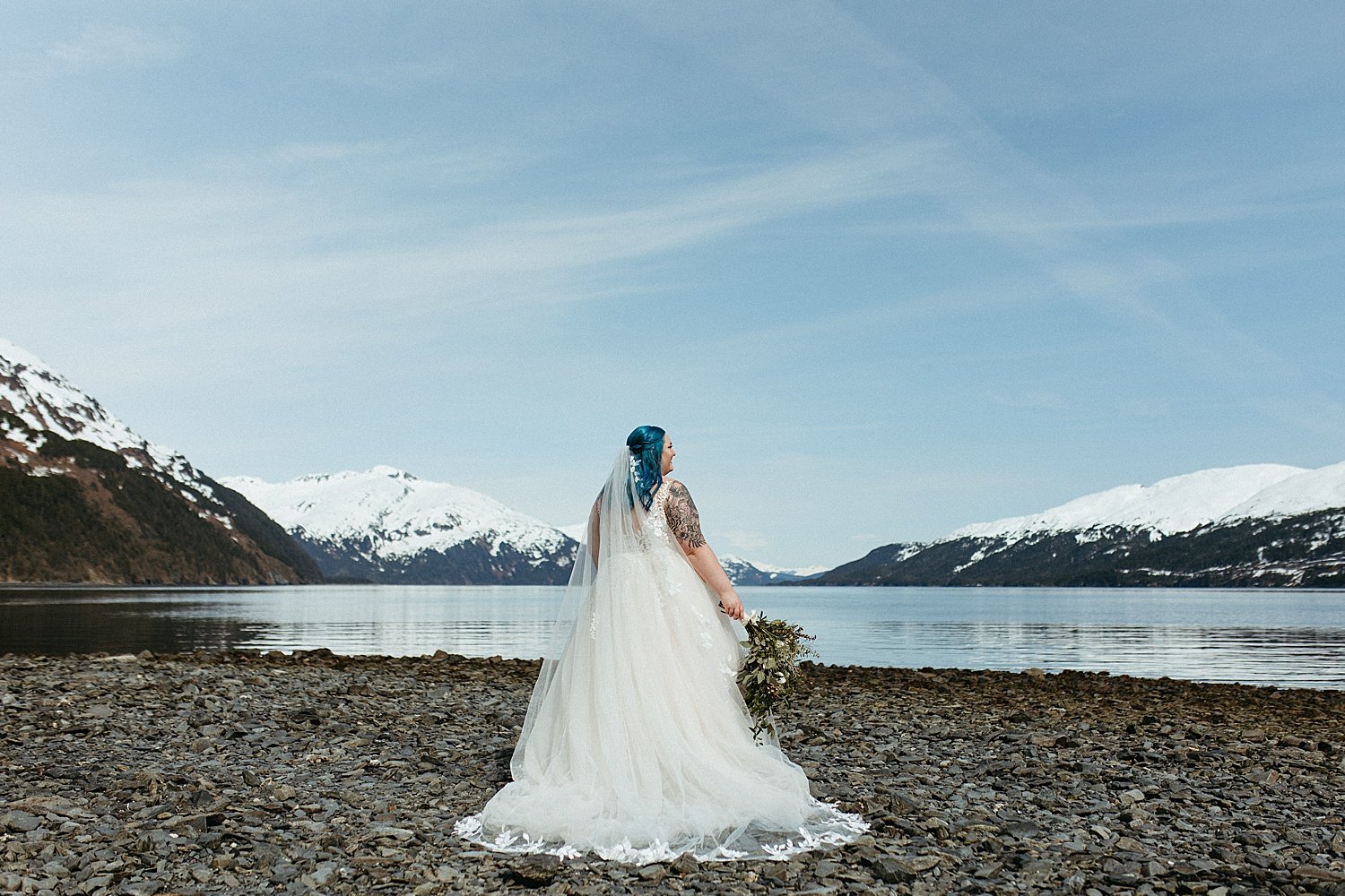  Stunning bride with blue hair standing in front of mountains by Alaska Elopement Photographer 