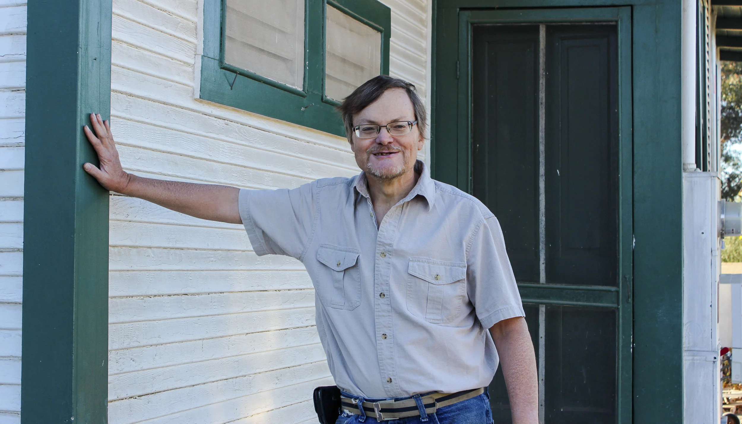 Former Interfaith shelter participant Brian poses in front of his new home.