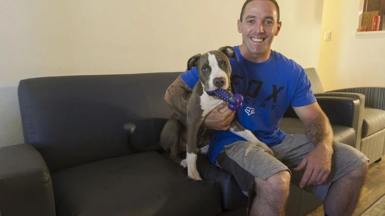 Ryan poses with his foster dog in his first apartment.