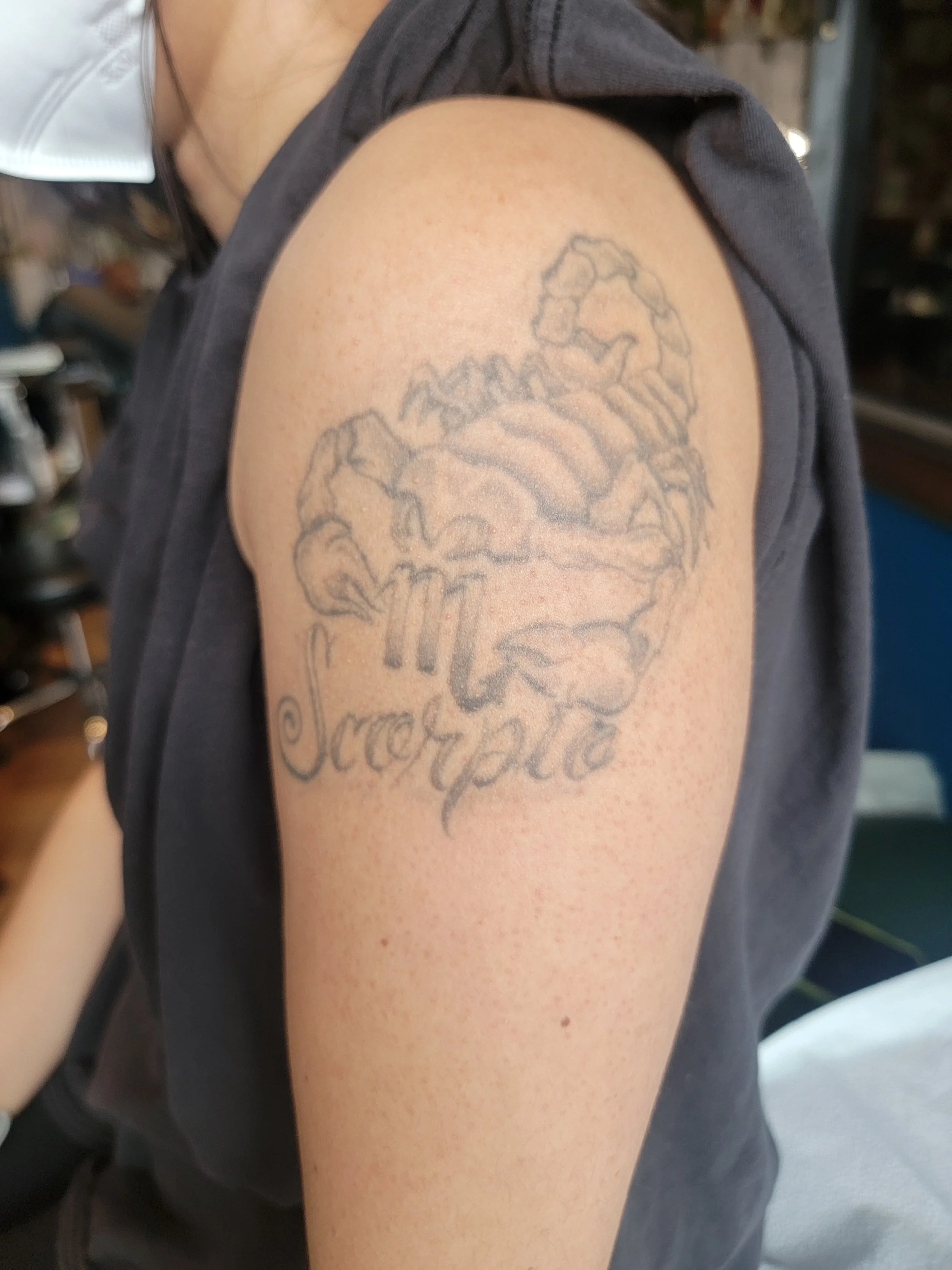 Tattoo of a scorpion and the word "Scorpio" that needs to be covered. Before cover up