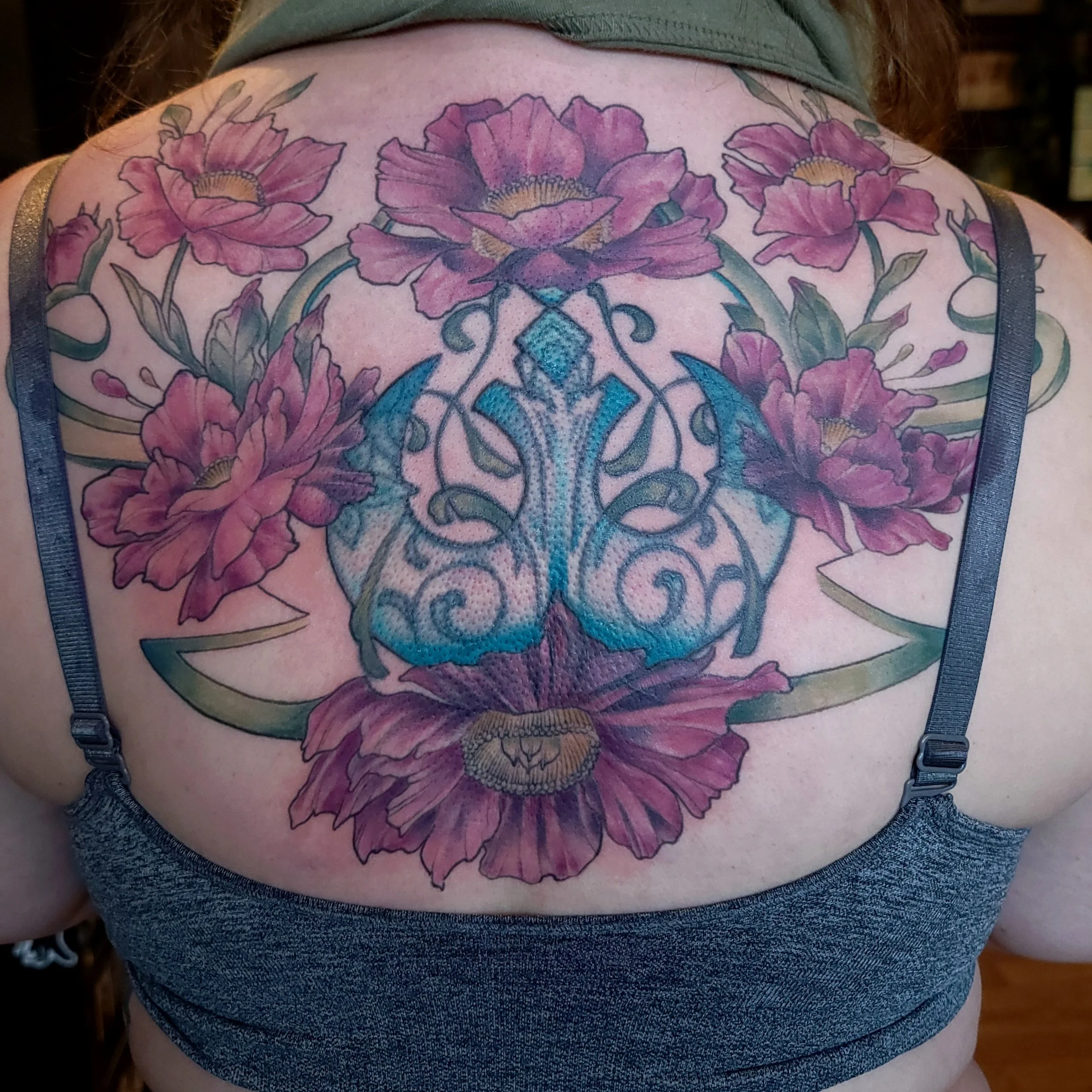 Tattoo of pink flowers and decorative pattern on a back to cover up mistakes and the fact the design in the center was originally off center. ..After cover up.