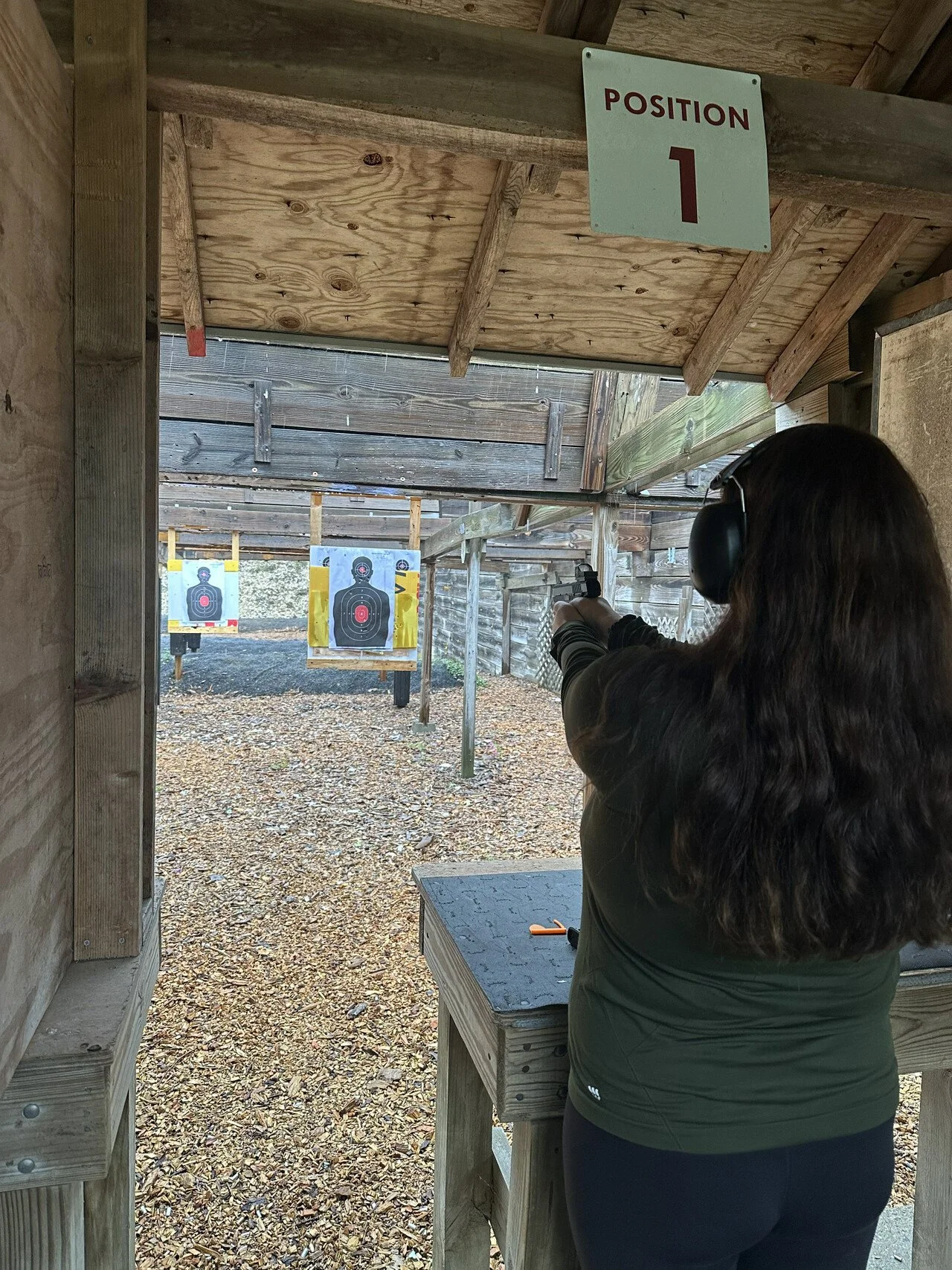  Looking downrange at the pistol range as a female shooters practices .  