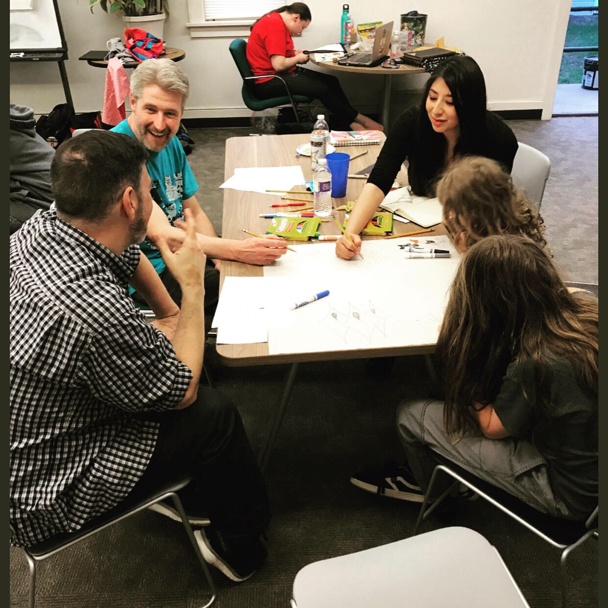  Community members and lead muralist Reyna Hernandez (center) brainstorm at the first design session, hosted by the Native American Cultural Center. 