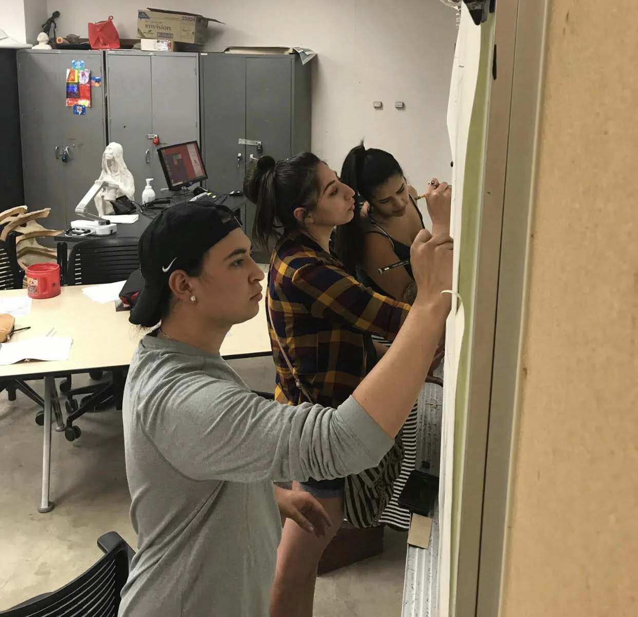 Muralists Inka Manni, Elizabeth Skye, and Reyna Hernandez translate design session feedback into a line art rendering.