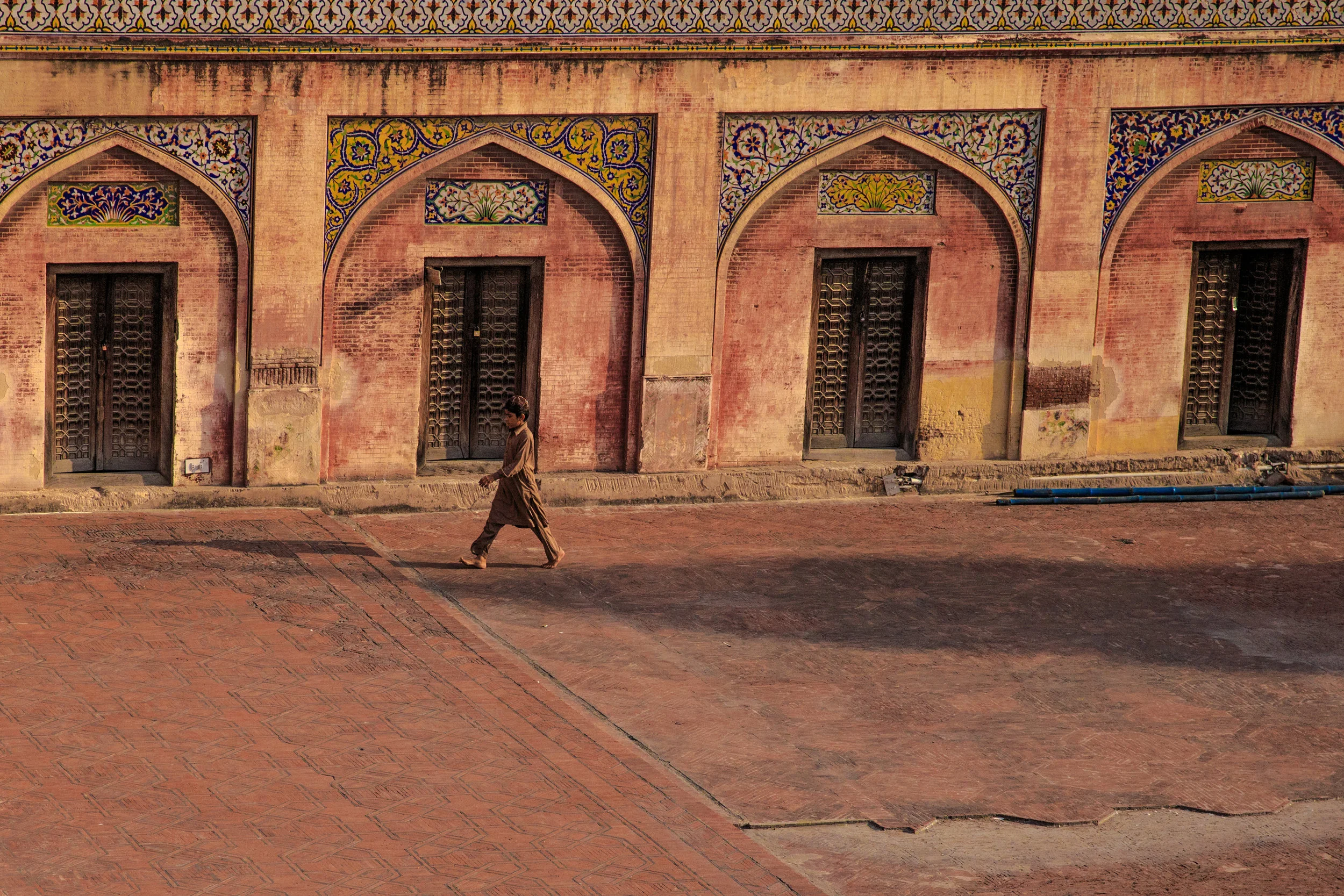 boy walking through mosque, photos of pakistan, street photography in pakistan, photography for sale, street photography for sale, travel photography