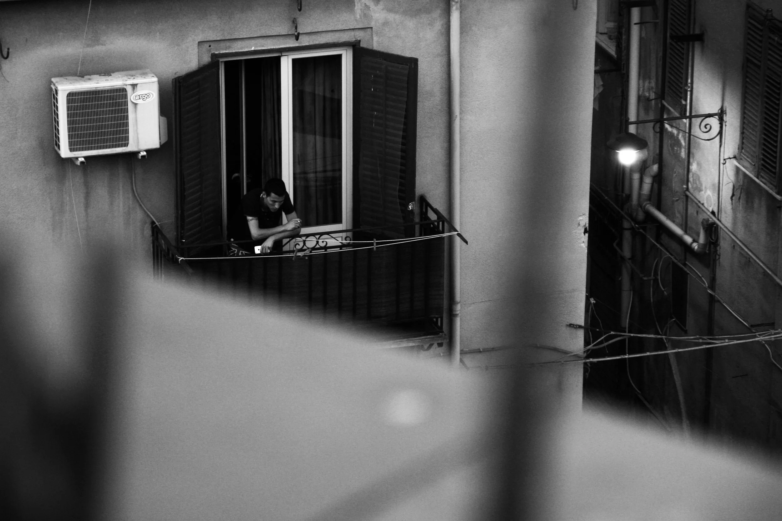 street photography, man on balcony overlooking street, italian streets, street photography for sale, street photography in italy