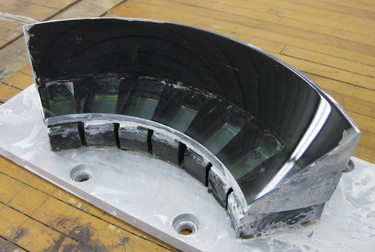 Lapped and polished lens (surface "A") awaiting reorientation for finishing sides "B" and "C"