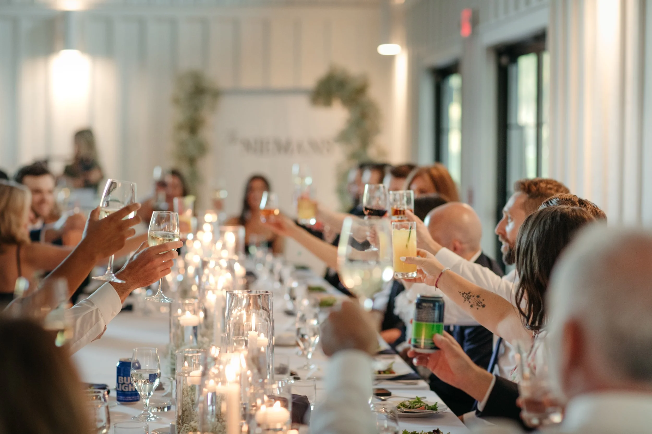 Guests raising a toast with wine and champagne at a candlelit reception dinner at Cliffside Acres, a private wedding estate in Springfield, Ohio