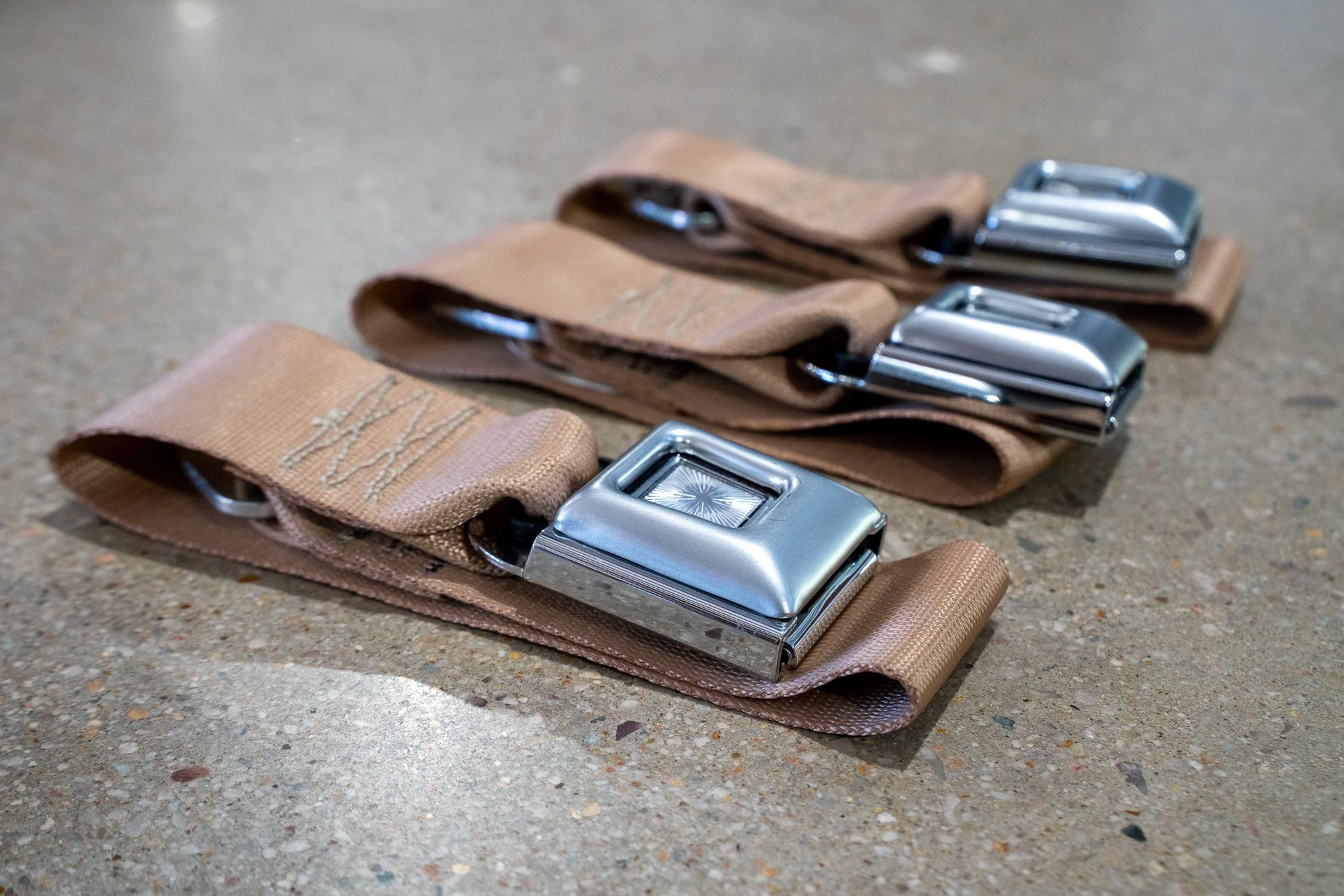 Jeep Heritage seat belt kit components laid out – custom-fit belts, sleeves, and hardware included