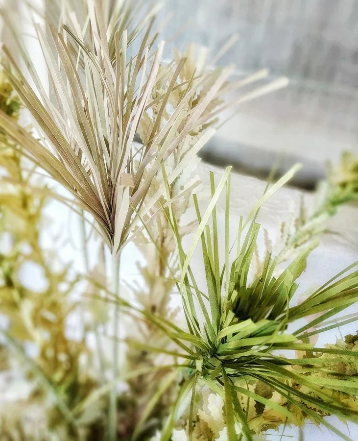 Above: Grass created with newsprint paper painted in different hues of green; then cut and applied to stems.