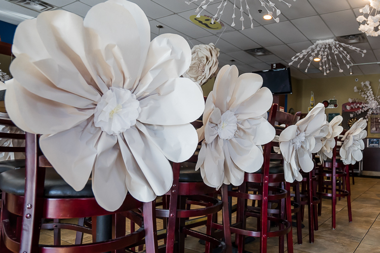 newsprint-paper-flowers-adorn-chair-backs.jpeg
