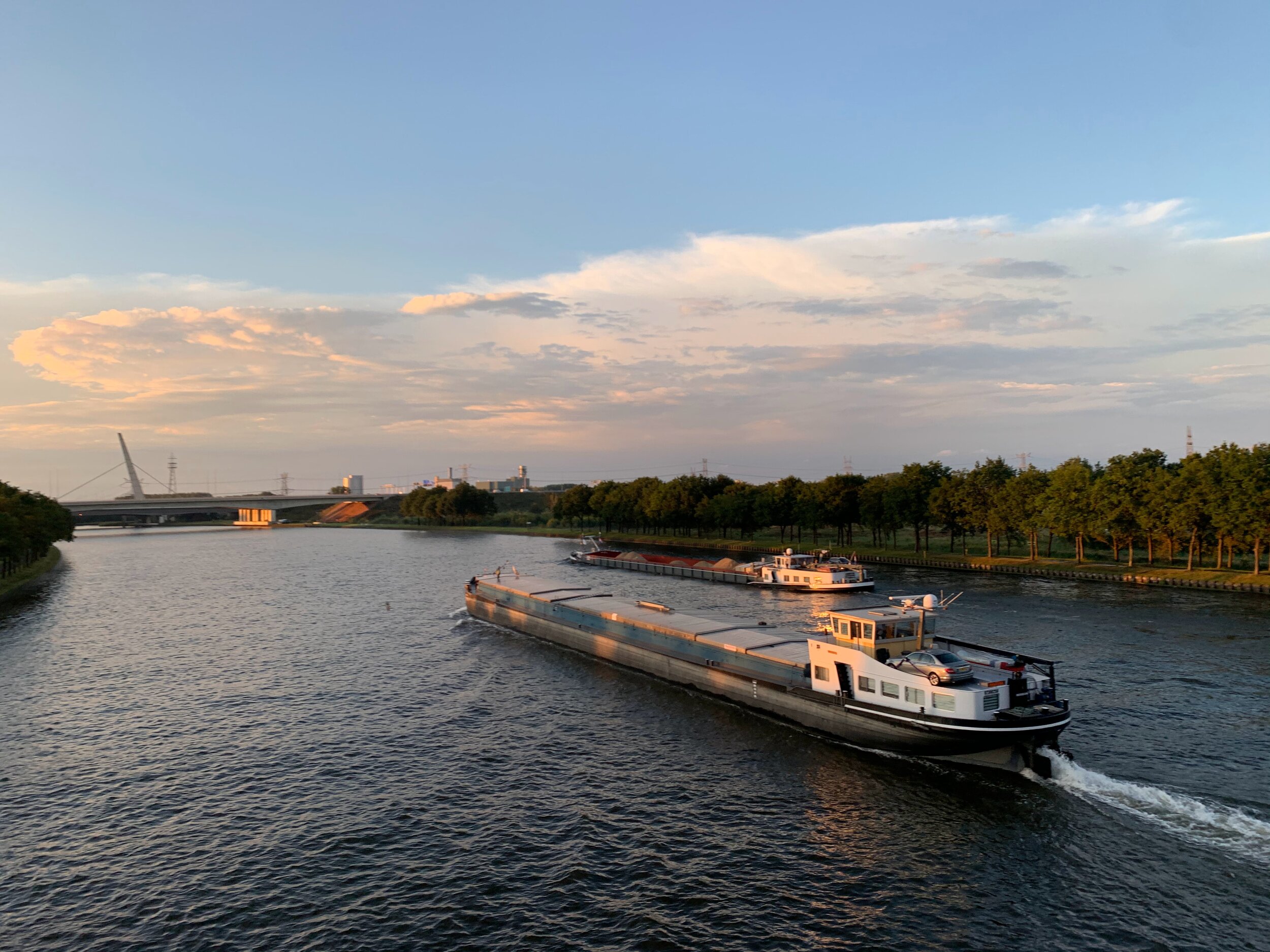 A barge travels down a river carrying cargo.
