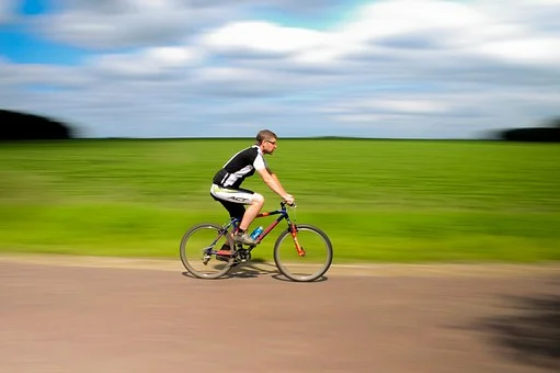 man riding a bicycle against a summer field background - how smooth is your wheel of life