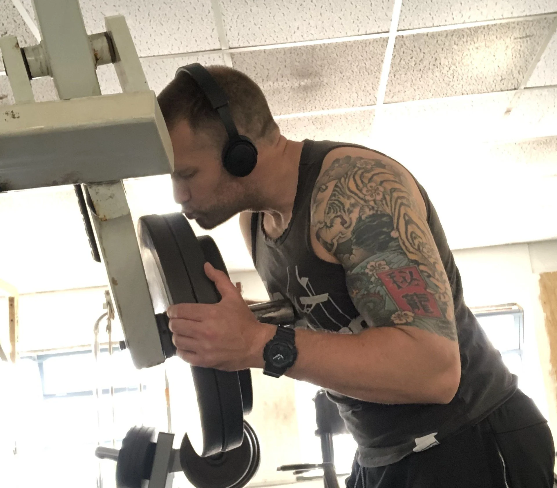 personal trainer in Brighton loads weights onto a bar