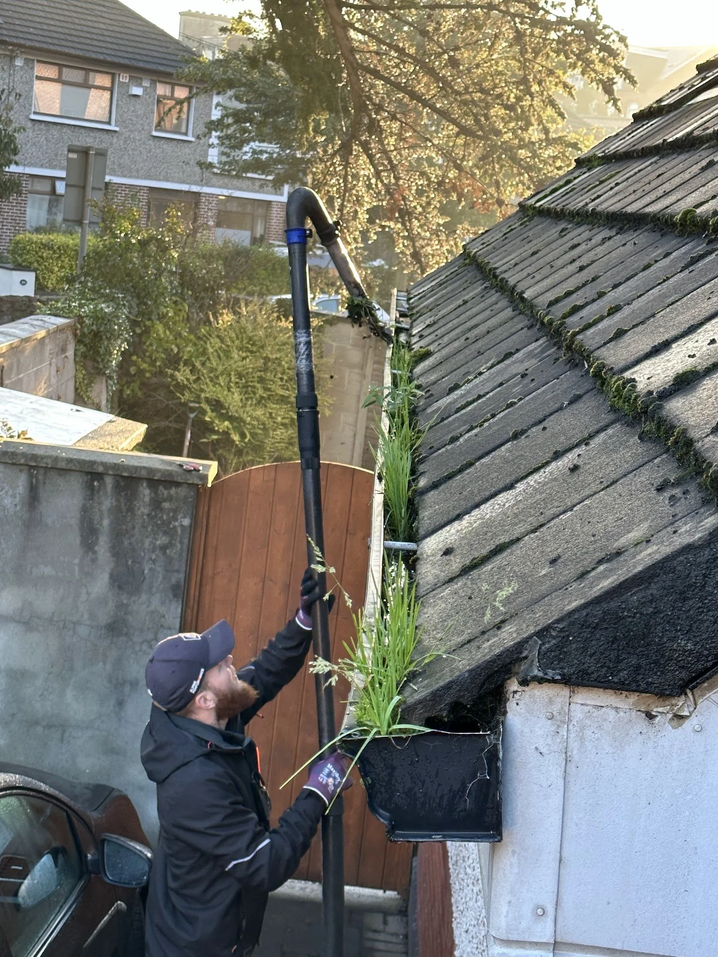 Base team member using professional gutter-vac equipment to clean gutters on a Dublin home.