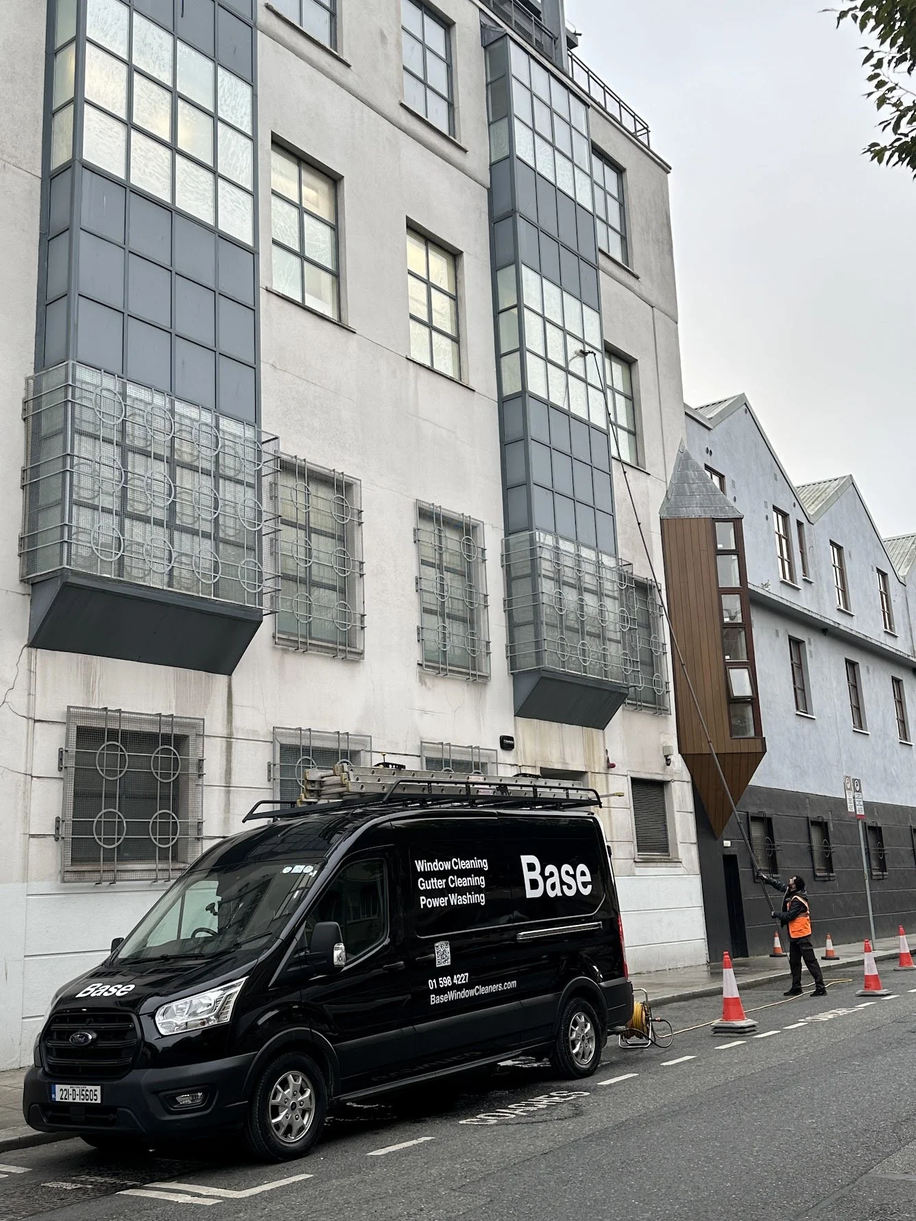 Base team member using professional high-reach equipment for commercial window cleaning in Dublin.