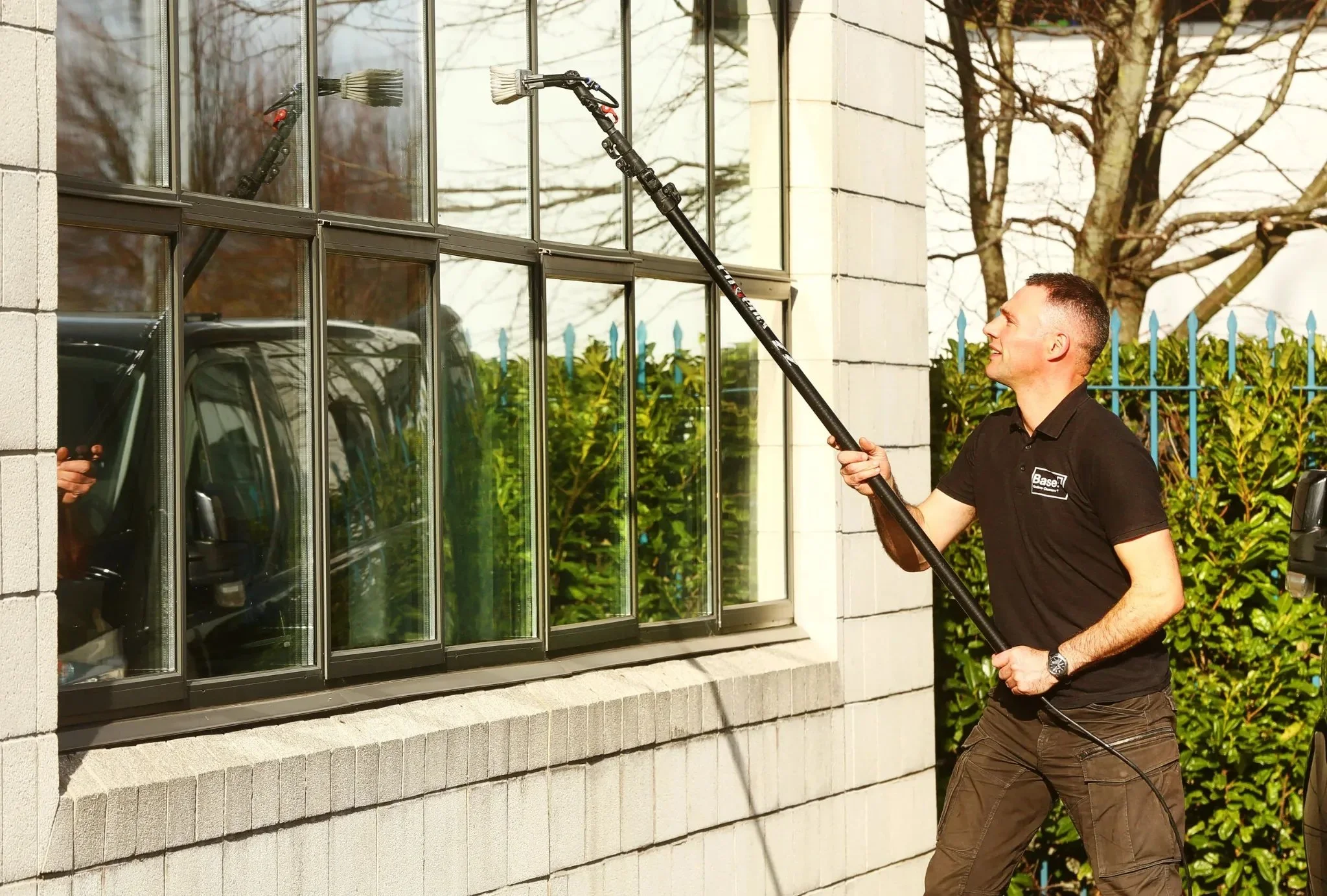 Base team member providing professional window cleaning at a Dublin property using water-fed pole equipment.