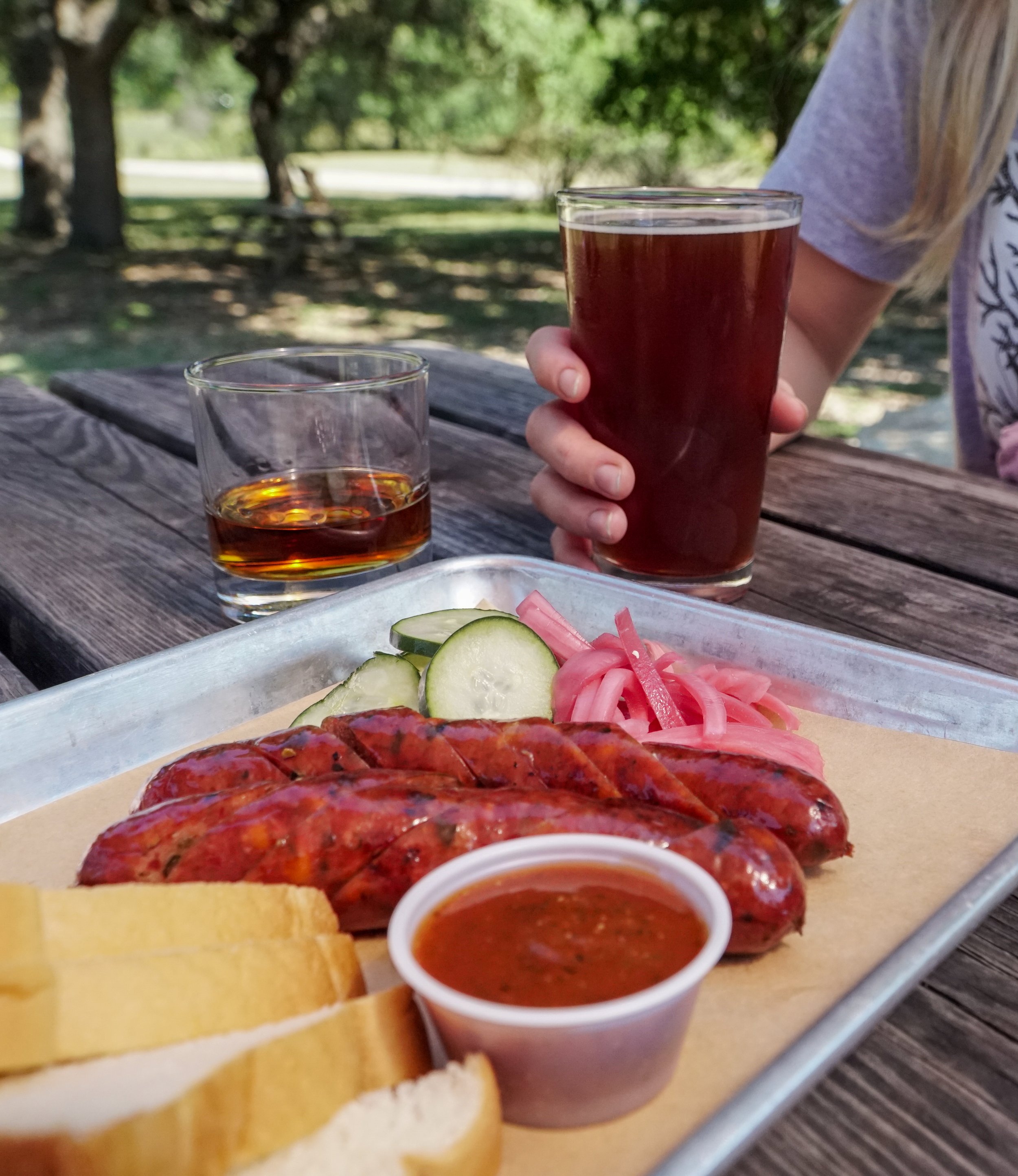 plate of sausage with side of bread and barbecue sauce