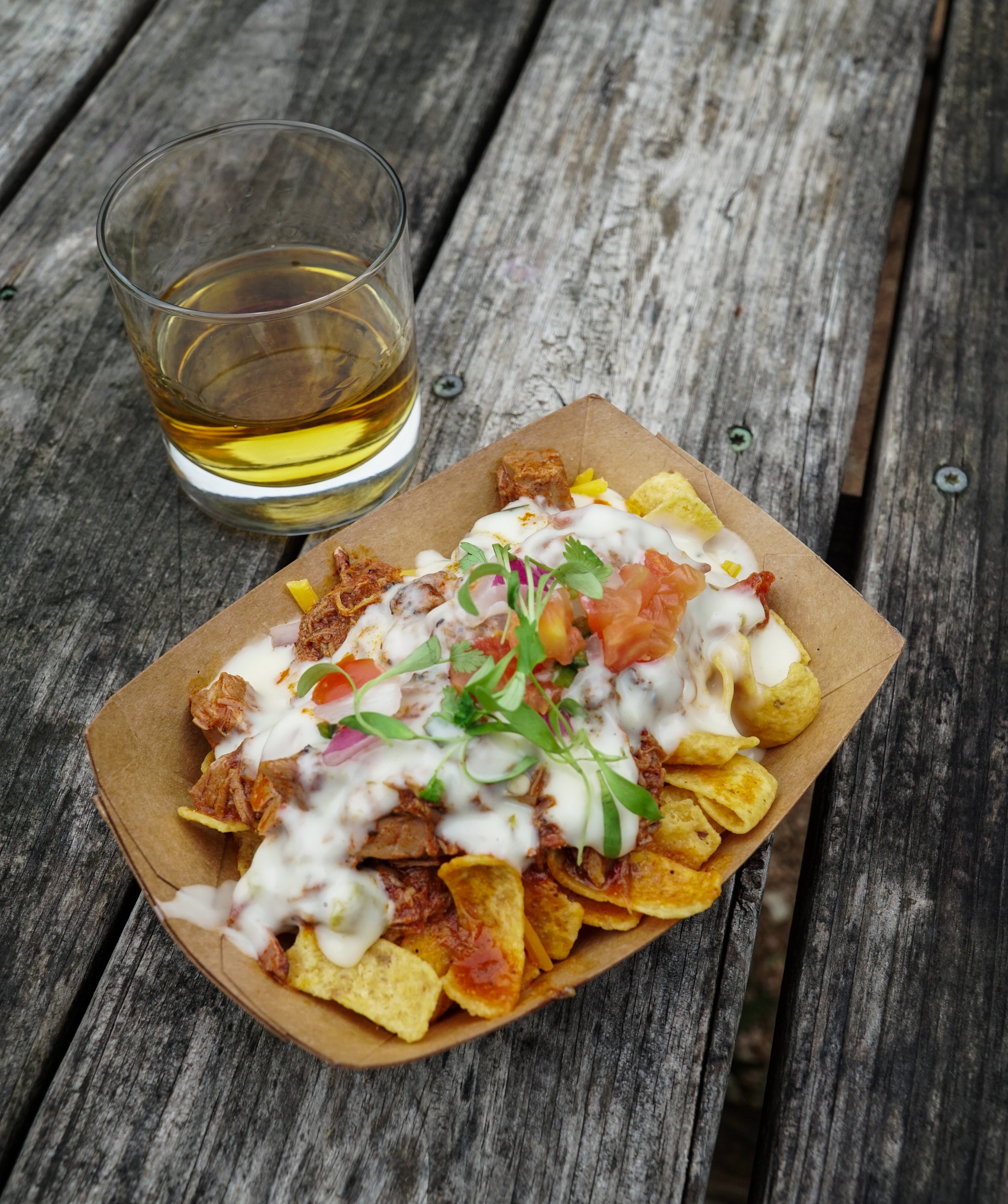 bowl of loaded frito pie and glass of whiskey