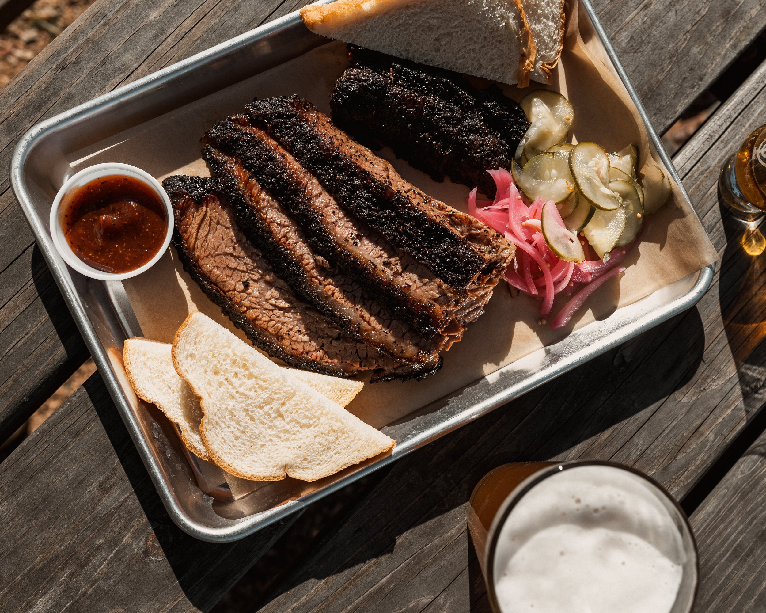 plate of sliced brisket and barbecue sauce