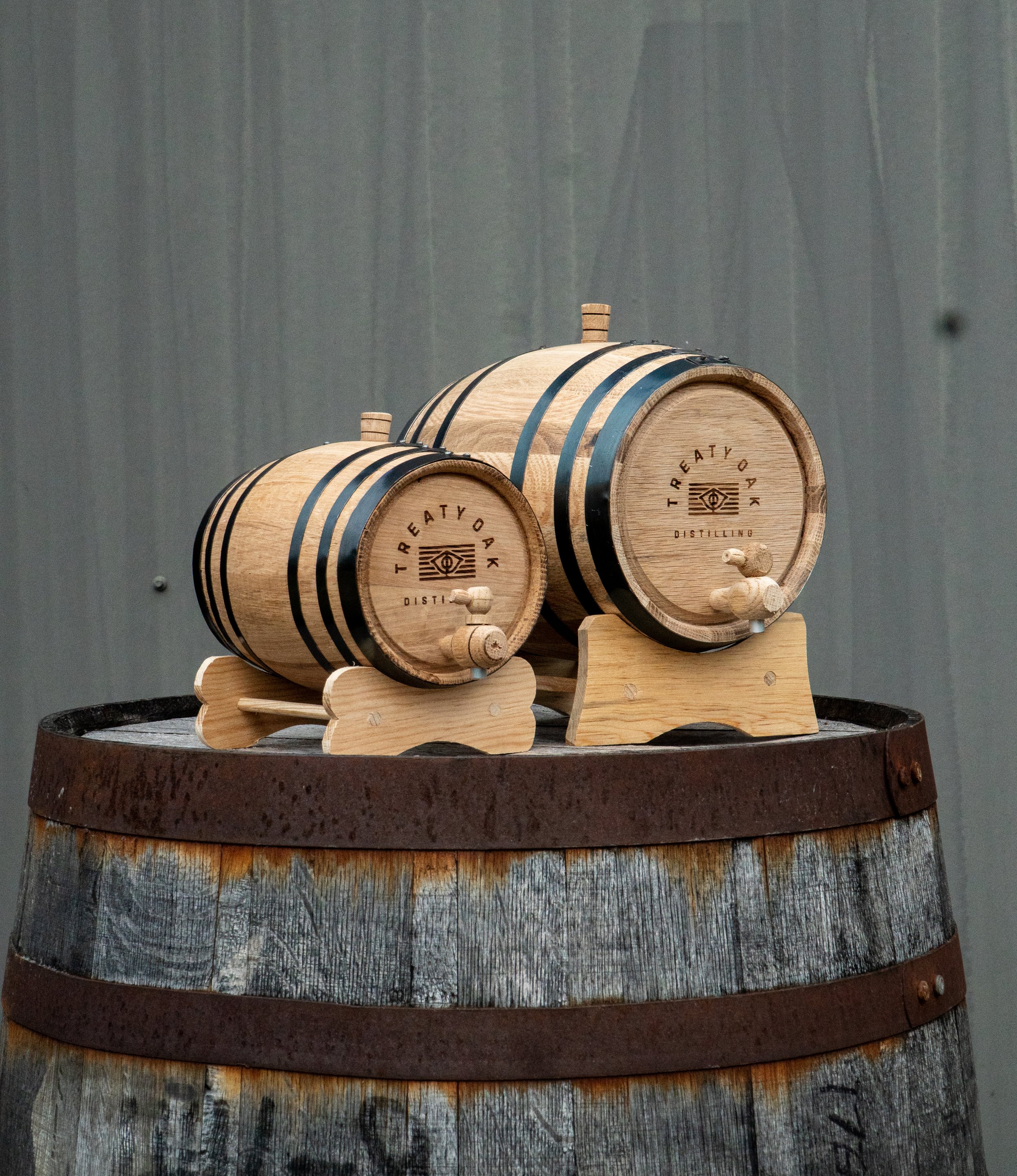 small whiskey barrels on top of a large whiskey barrel