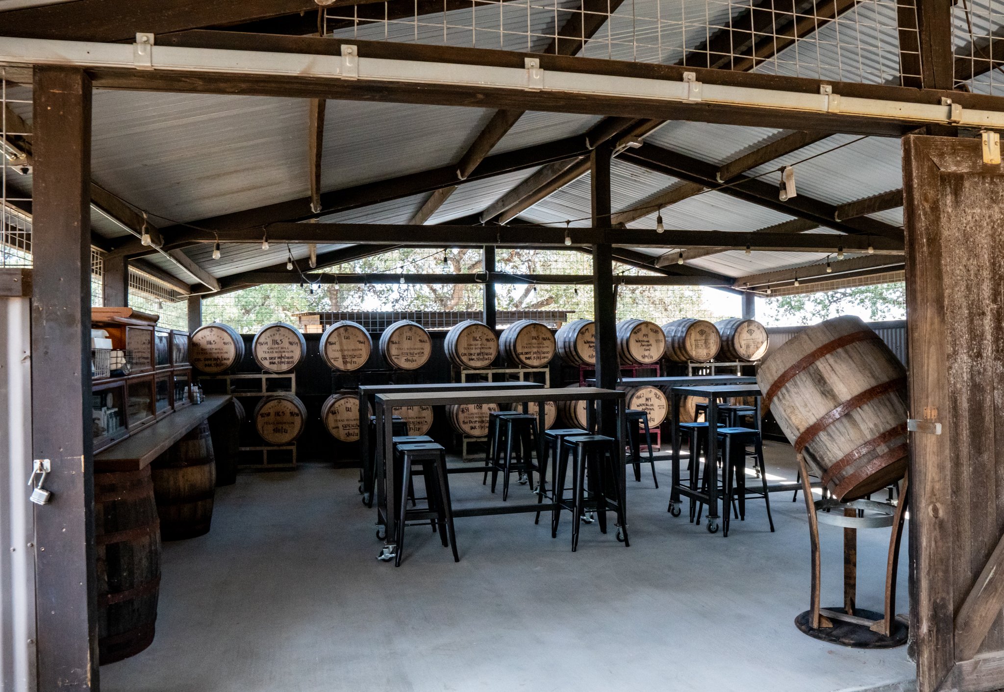 Barn with whiskey barrels, tables, and chiars