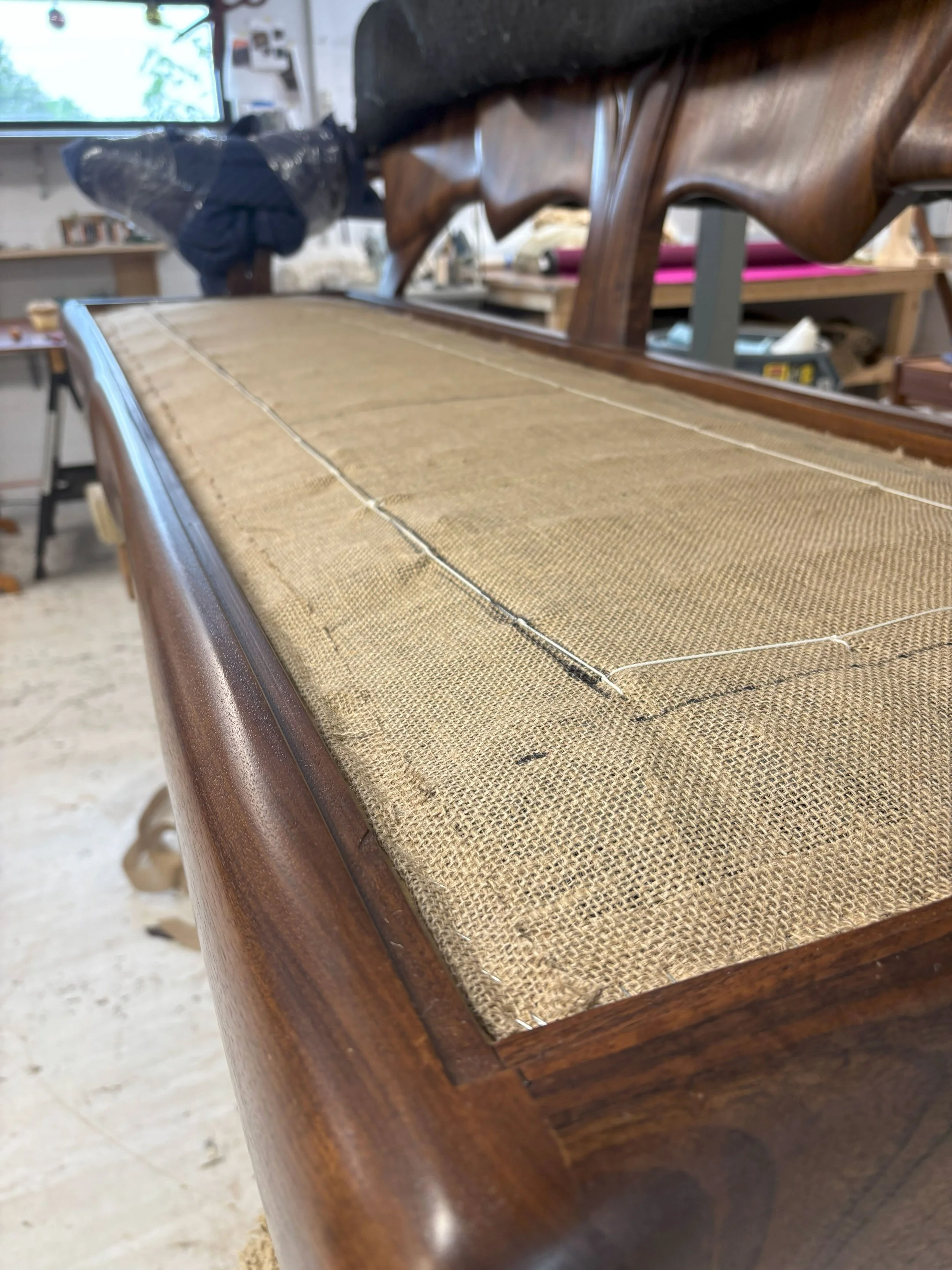 Close-up of the sofa as it getting the upholstery over the spring box