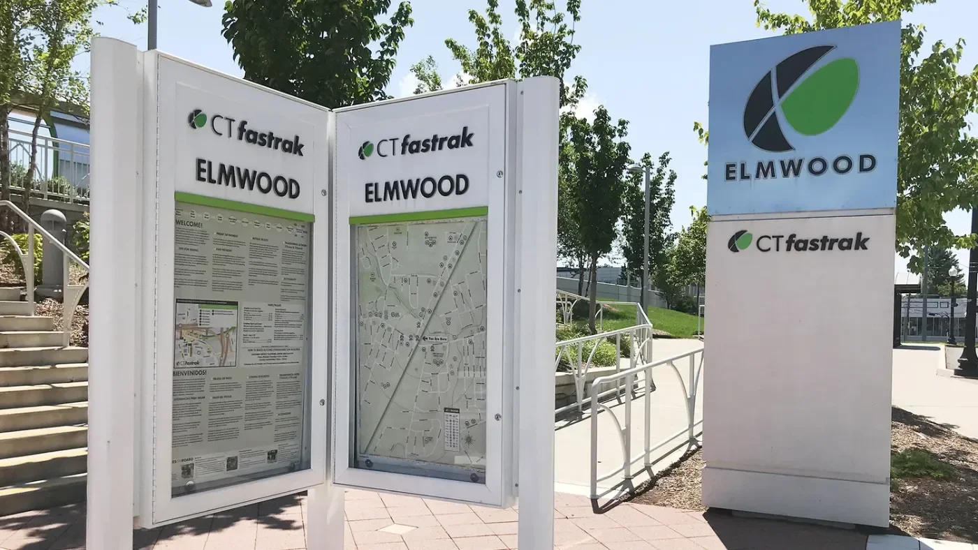 CTfastrak Elmwood Station sign with the wayfinding map displayed in a case beside the platform