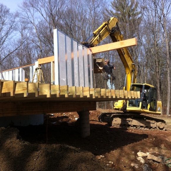  on-site excavator aids in placing a large beam 