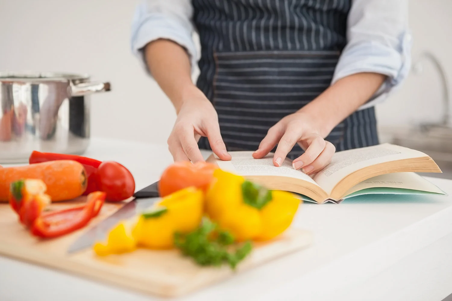 woman cooking with recipe book