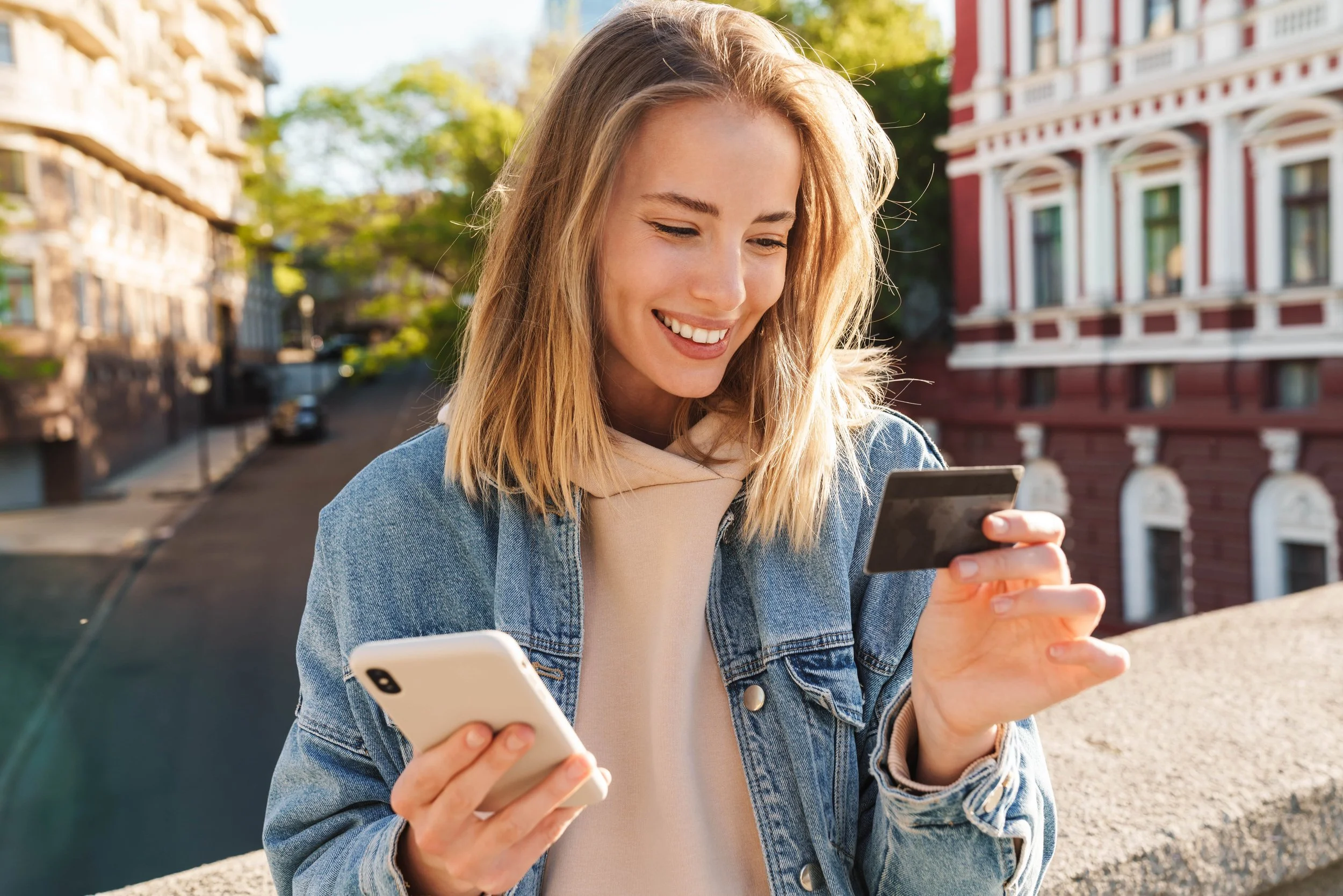 image of a lady holding a smart phone and credit card