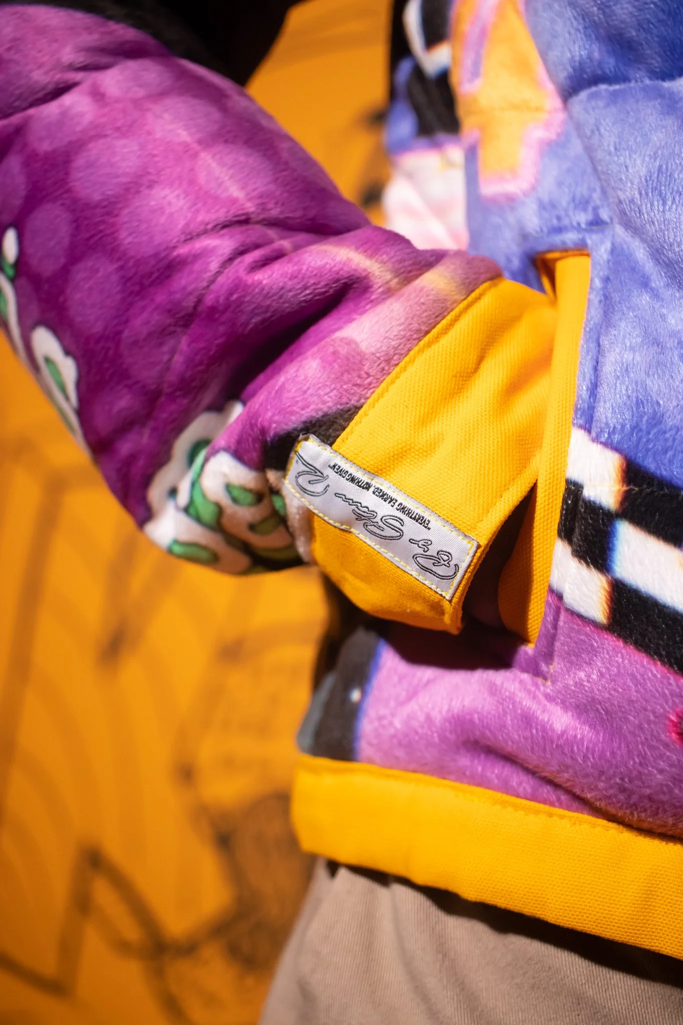  Close-up detail of the sleeve cuff, highlighting construction finish and integrated self-label branding. 
