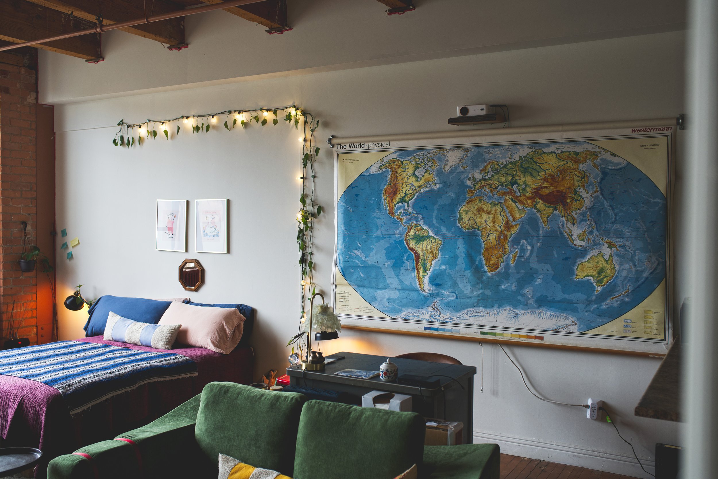 Cozy bedroom with a bed, pillows, string lights, and wall art.