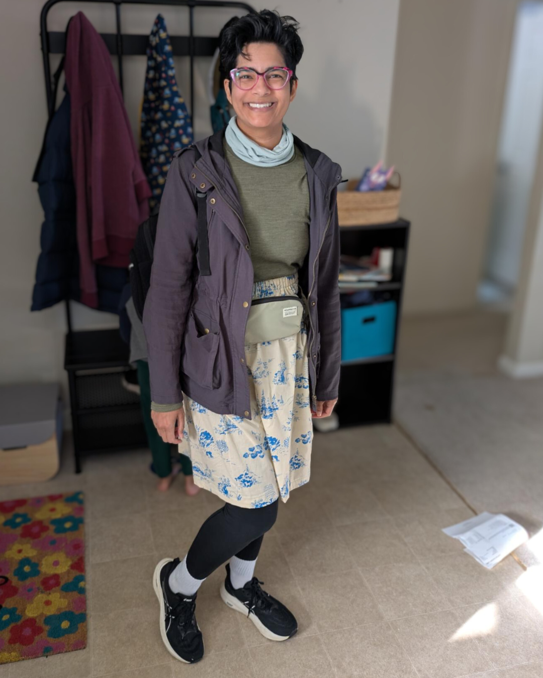brown woman smiling and standing in a house