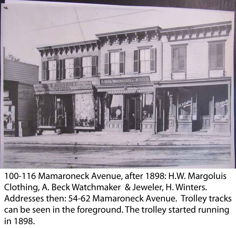  100-116 Mamaroneck Avenue, after 1898: Address then, 54: H.W. Margoluis Clothing, A. Beck Watchmaker &amp; Jeweler, H. Winters. Addresses then: 54-62 Mamaroneck Avenue. Trolley tracks can be seen in the foreground. The trolley started running in 189