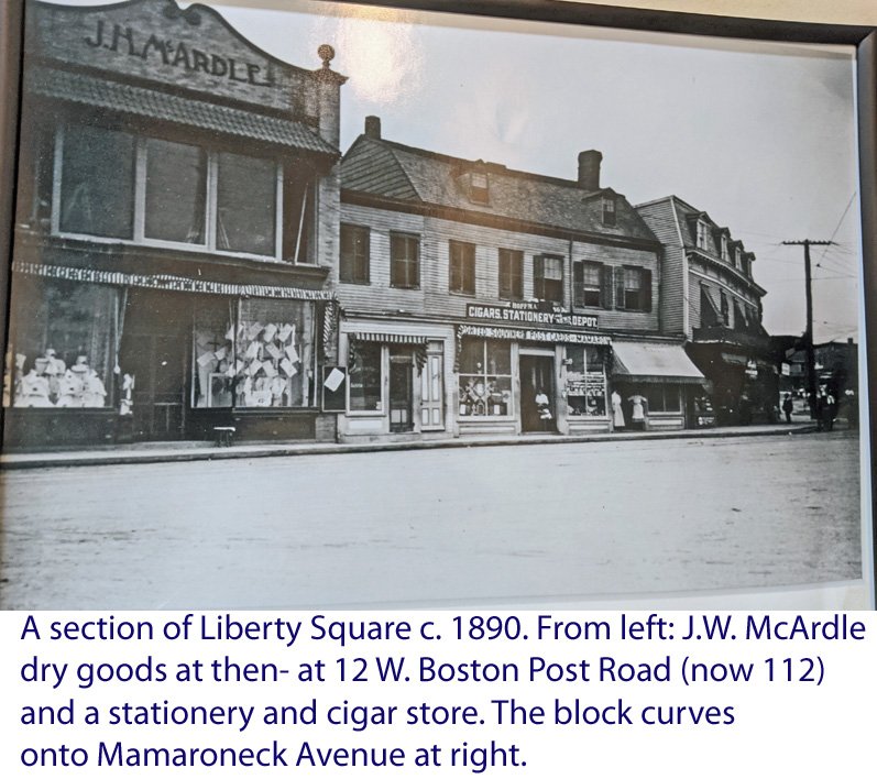  A section of Liberty Square in Mamaroneck c. 1890. From left: J.W. McArdle dry goods at then-12 W. Boston Post Road (now 112) and a stationery and cigar store. The block curves onto Mamaroneck Avenue at right.&nbsp;  