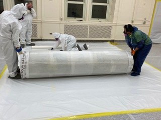  Cutting the protective sheet for size after the mural was rolled onto it. 
