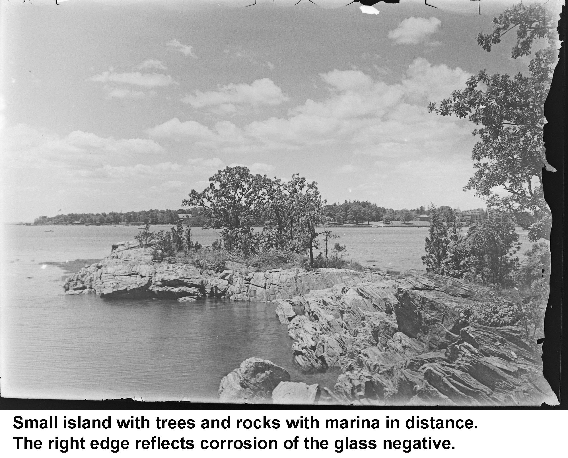 GN-054 Small island with trees and rocks with marina in distance.jpg