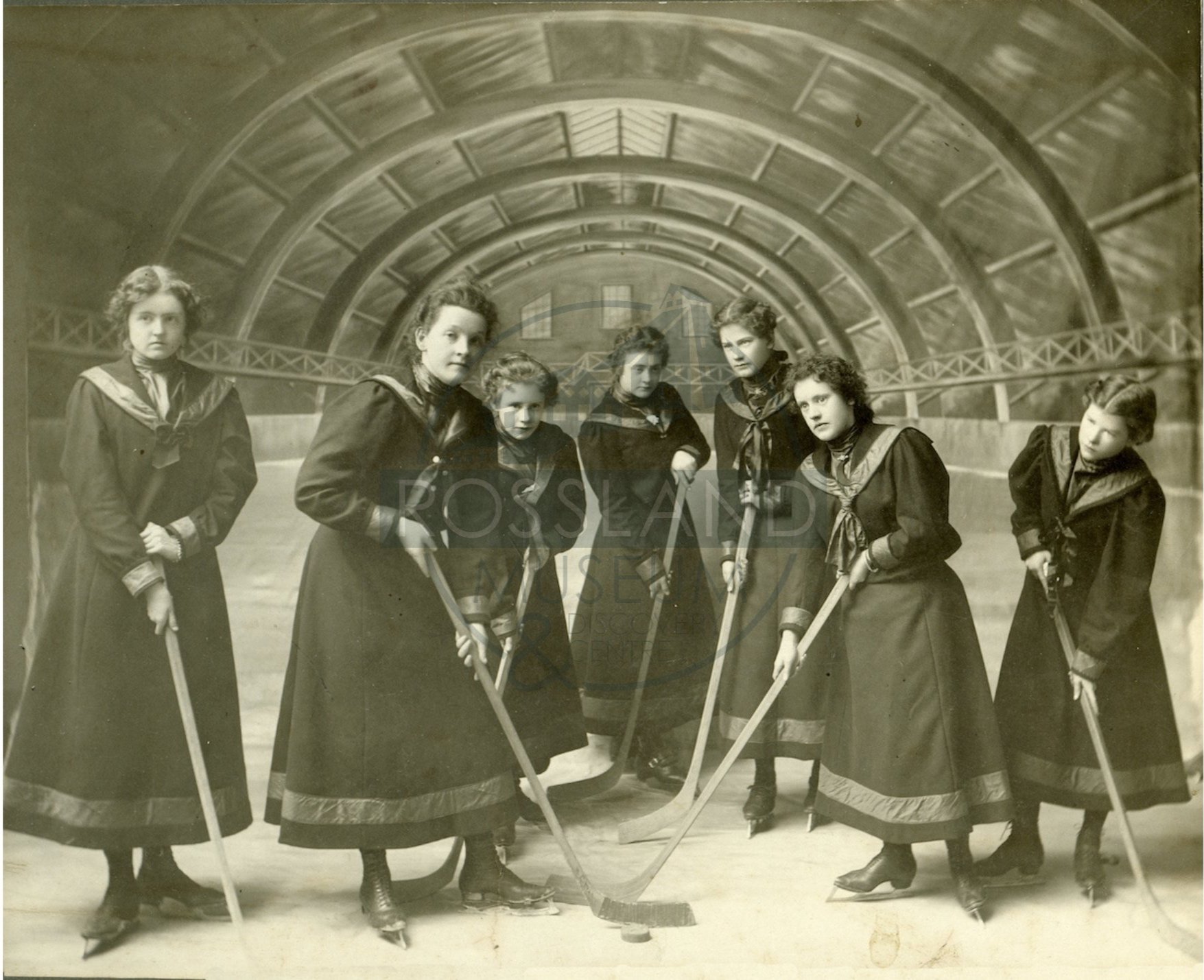   2285.0006 : Rossland Ladies’ Hockey Team in the Rossland Arena, circa 1900.  Left to Right: Alice Cooper, Blackman, Mellie Inches, Effie Agnew, and Alice Northy. 