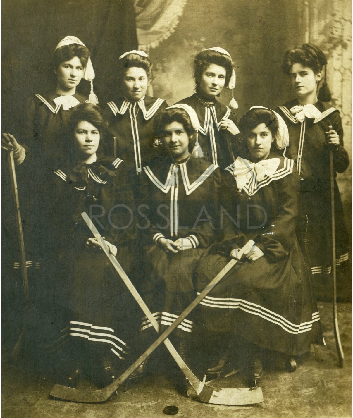   2285.0021 : Rossland Ladies’ Hockey Team, 1906.  Pictured: Mary Milne (Captain), Eva Blackman (Goalie), Ethel Blackman (Defence), Frances Honey (Center), Reba Demutm (Left Wing), Hazel Blackman (Right Wing), and Johanna Aconite Defence). 