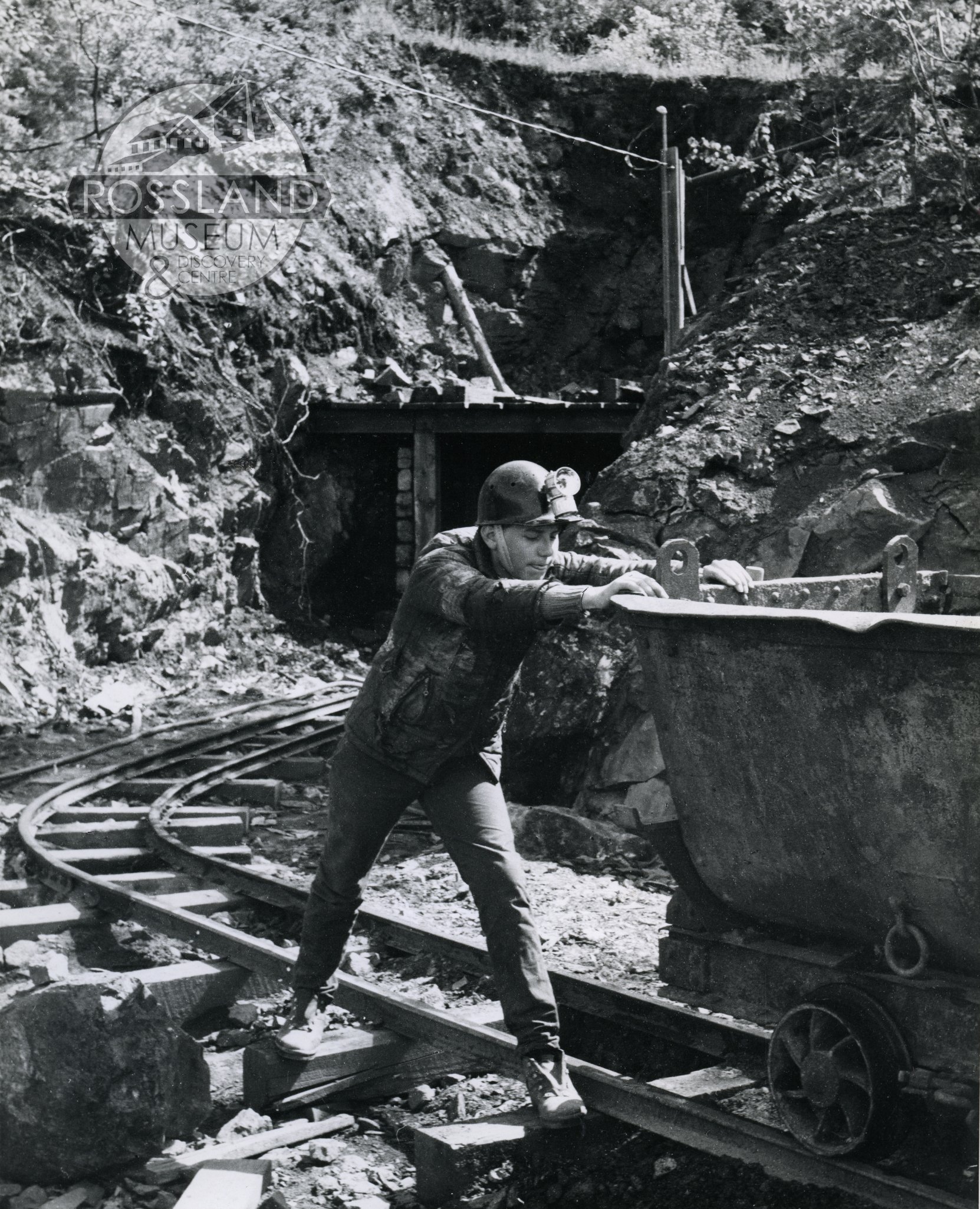 Photo 2276.0128: Ricky Greene pushing Mine Muck car at the portal of the Black Bear tunnel, 1967